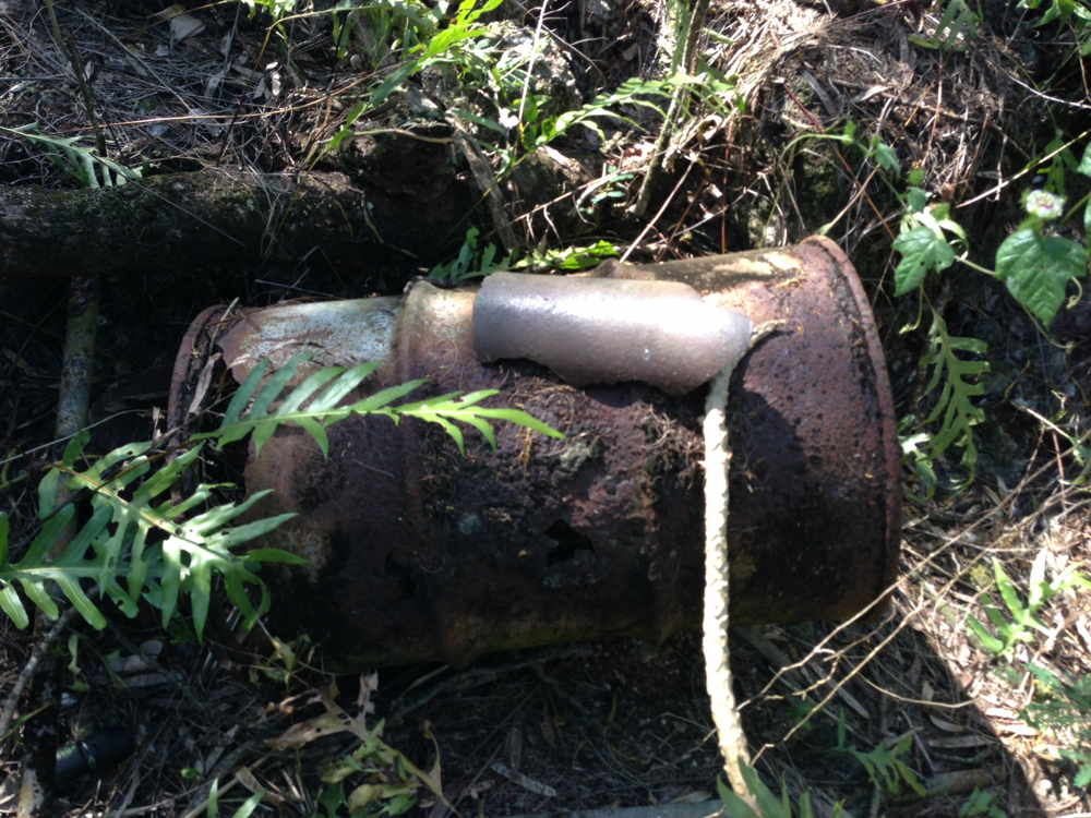 064-abandoned_55_gallon_fuel_drum_and_shell_fragment.jpg